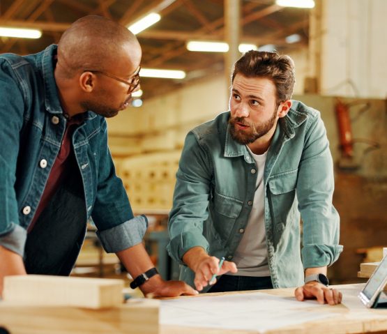 Carpentry, meeting and men in workshop for woodwork on furniture, restoration and lumber manufactur